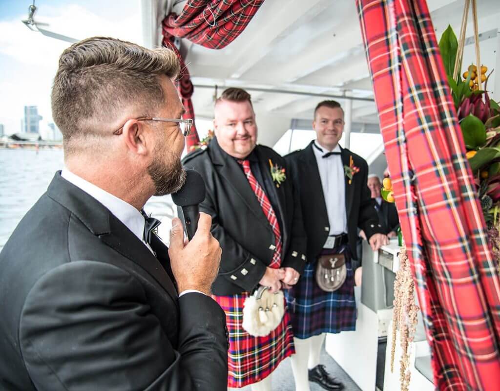 A groomsman speaking at a wedding on a boat