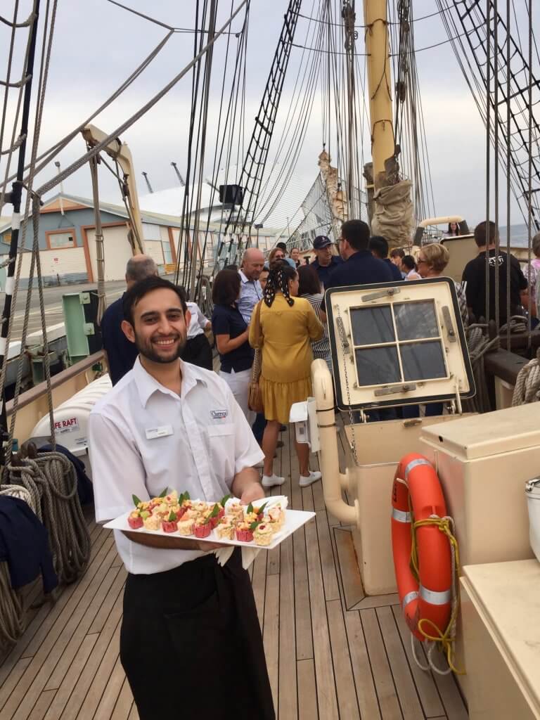 Cherry's Catering staff serving a plate of platter in a ship